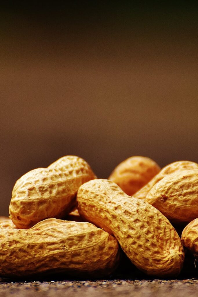 A focused close-up of unshelled peanuts on a rustic surface with earthy tones.
